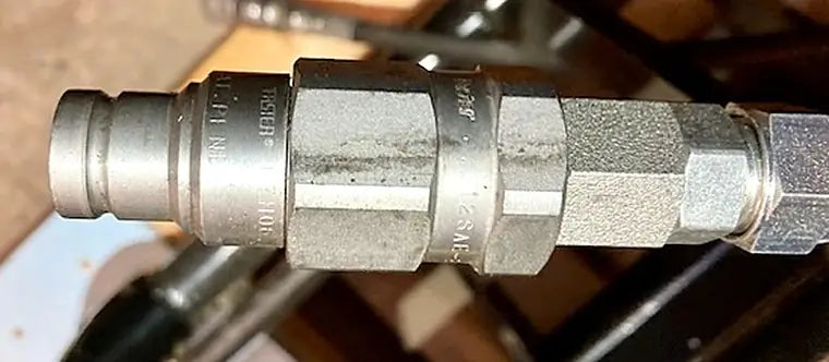 Example photo 1: side view of a male hydraulic coupler end with the stamped markings visible